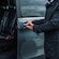 A driver opening the door to a private minibus